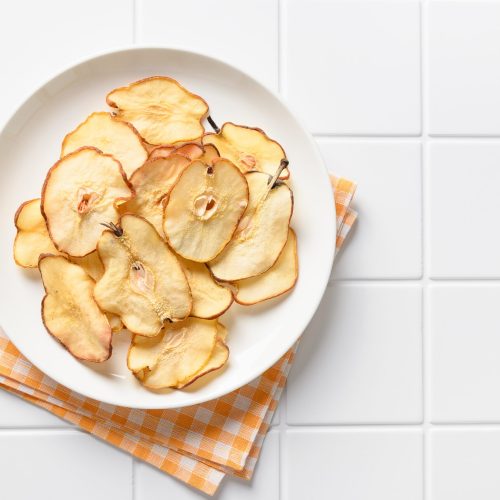 fruits pear chips on a white tiled background veg utc